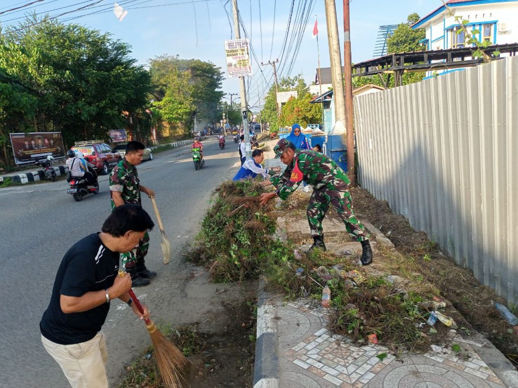 Terlihat Babinsa bersama masyarakat membersihkan saluran air